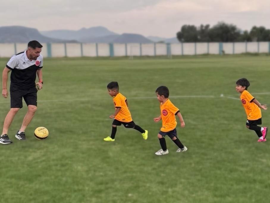 Niños jugando fútbol en la Academia